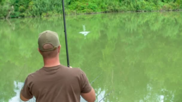 A fisherman is fishing on a nice summer day. - Footage, Video