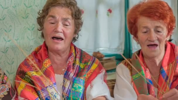 Deze oudere dames zitten nog steeds vol leven en zingen liedjes. Ze dragen mooie en kleurrijke sjaals. - Video