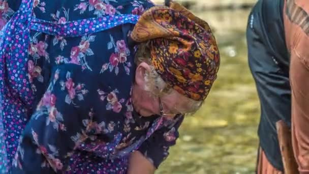 Работающие пожилые женщины стирают одежду в реке. Вот как они делали это раньше.. - Кадры, видео