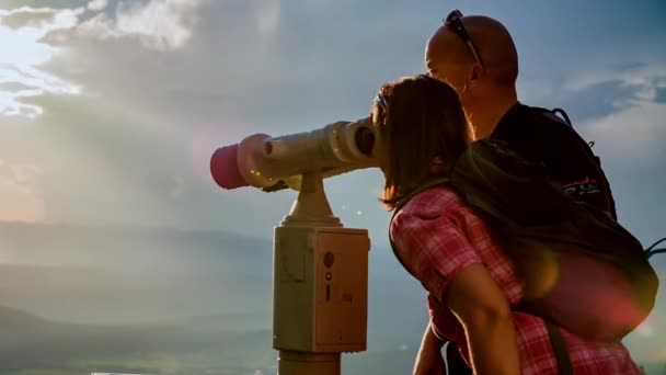 Dva lidé dosáhli vrcholu hory a pozorují výhled dalekohledem.. - Záběry, video