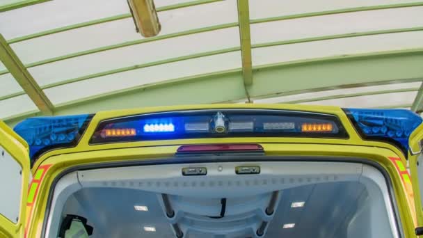 Μπλε και κίτρινα φώτα στην οροφή του ασθενοφόρου είναι αναμμένα και πάλλονται. - Πλάνα, βίντεο