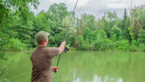 A fisherman is throwing a fishing rod very far away into the water. - Footage, Video