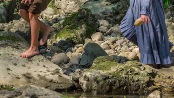 Pienet lapset pääsevät joelle pienet esineet käsissään ja he jättävät nyt nämä esineet uimaan pois jokeen.. - Materiaali, video