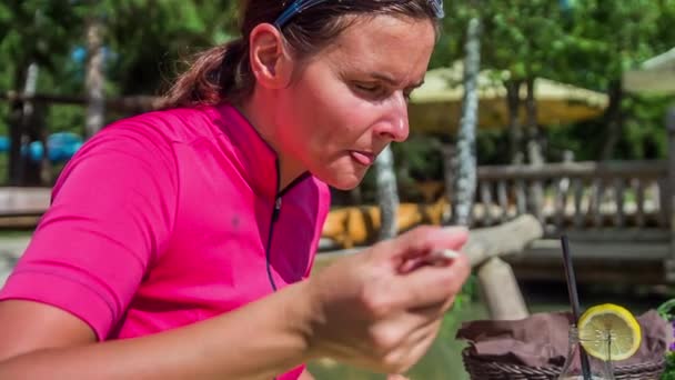 Een vrouw eet een stoofpot. Ze heeft een pauze na een succesvolle wielersessie. - Video