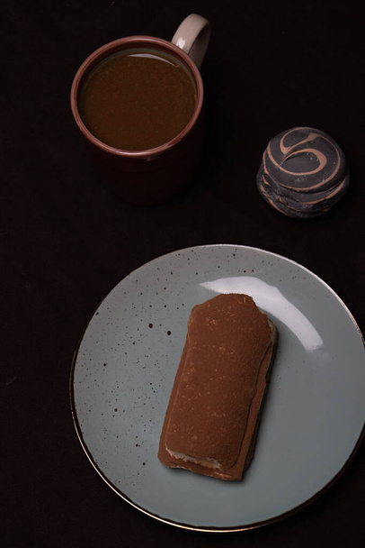 Morning breakfast of coffee and sweet marshmallows and tiramisu on dark background. - Photo, Image