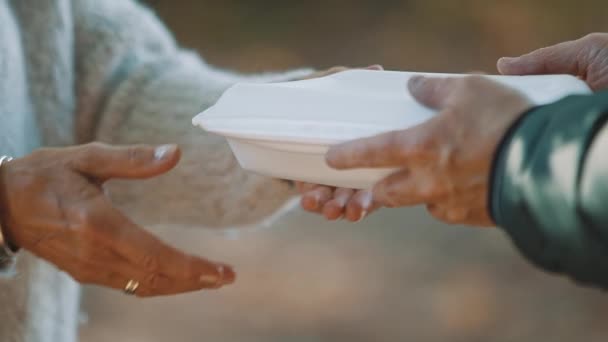 nő önkéntes segít etetni a hajléktalanokat ingyen étellel. Közelkép.  - Felvétel, videó
