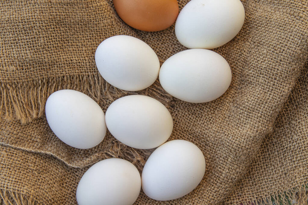 Huevos de pollo crudos orgánicos en tela de arpillera. Huevos de pollo frescos. Vista desde arriba - Foto, imagen