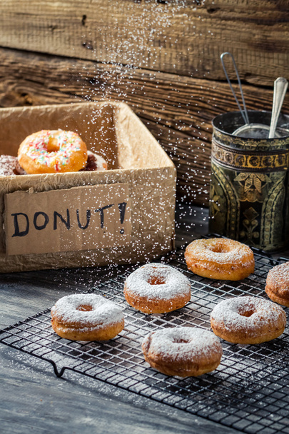 Closeup of falling icing sugar on fresh donuts - Zdjęcie, obraz