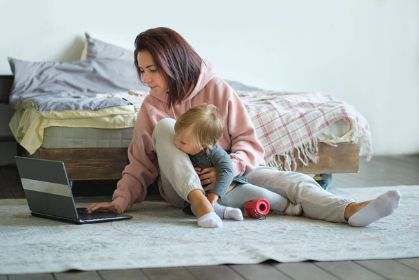 Egy nő, aki otthonról dolgozik, babával az ölében. Anya és gyermek Szülői Anyaság Szerelem Care Concept - Fotó, kép