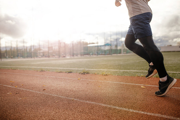 Спортивний майданчик. Ноги працюють на біговій доріжці на заході сонця. концепція здорового способу життя
 - Фото, зображення
