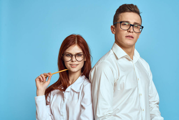 business woman and colleague man on a blue background in light clothes and documents in hands work - Foto, imagen