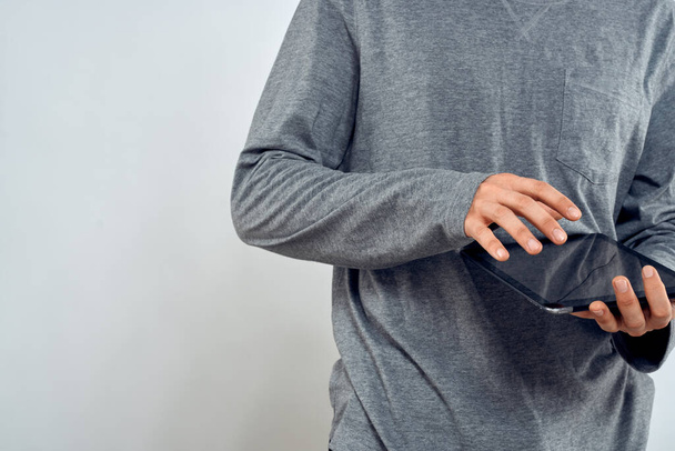 Muž s tabletem v ruce technologie životní styl internet komunikace práce světlo pozadí oříznutý pohled - Fotografie, Obrázek
