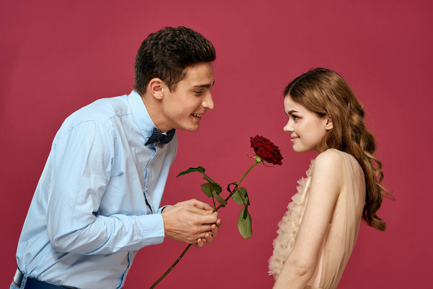 portrait of romantic couple in love with red rose on isolated background and classic suit evening dress - Фото, изображение