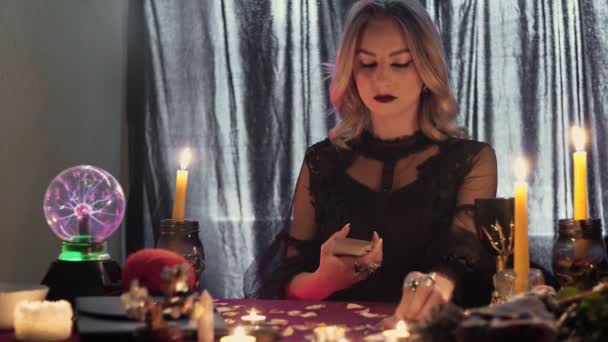 Young fortune teller at the table by candlelight reads the future on the cards in the smoke - Footage, Video