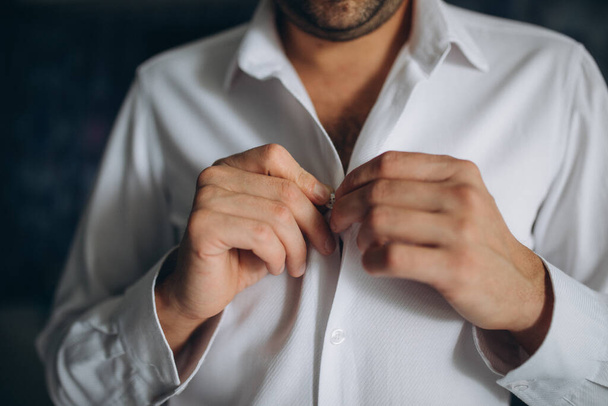 people, business, fashion and clothing concept - close up of man dressing up and fastening buttons on shirt at home - Fotoğraf, Görsel