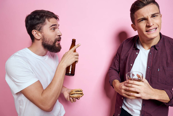 Dois homens bebem cerveja amizade bêbado álcool estilo de vida rosa fundo - Foto, Imagem
