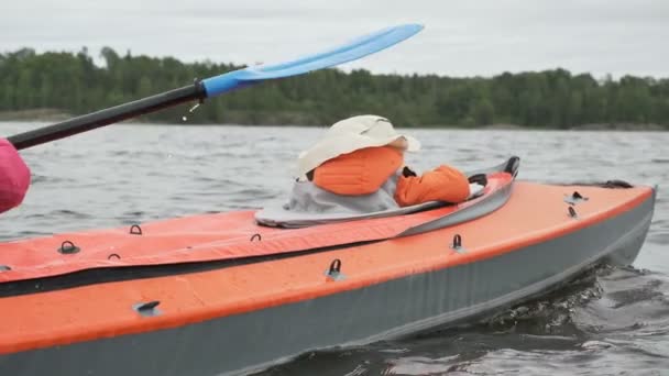 Kleines Kind segelt mit glücklicher Mutter im Kajak auf großem See - Filmmaterial, Video