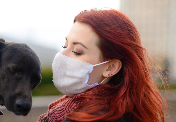Młoda samica używająca maski jako koronawirusu rozprzestrzeniającego profilaktykę spaceru z psem. - Zdjęcie, obraz