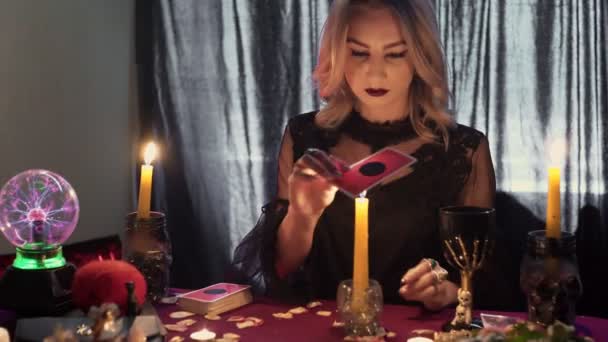 Wahrsagerin bewegt eine magische Tarokarte über eine Kerze - Filmmaterial, Video