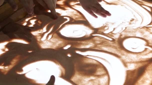 Μια ομάδα παιδιών ζωγραφίζει με άμμο στο γυαλί. Μάθετε να σχεδιάζετε με άμμο στο γυαλί. - Πλάνα, βίντεο