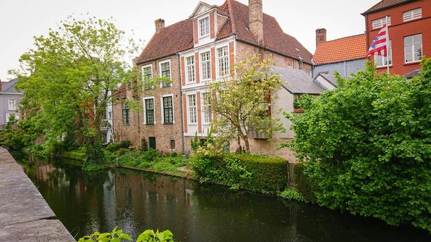 Piękny widok na autentyczne domy nad kanałem w belgijskim mieście Brugia. - Zdjęcie, obraz