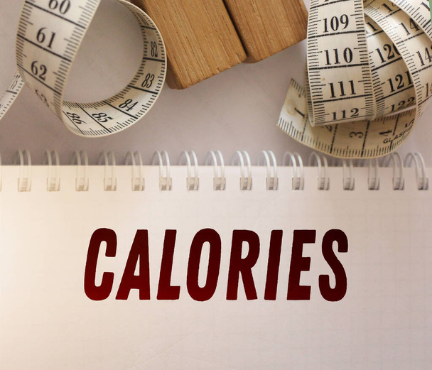 Copybook se slovem kalorie a měřicí páskou. Slim koncept. - Fotografie, Obrázek