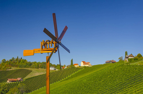 Güney Styrian Şarap Yolu boyunca uzanan üzüm bağları ve yel değirmeni, Avusturya ile Slovenya arasındaki yeşil kayan tepeler, üzüm bağları, pitoresk köyler ve şarap tavernaları arasında büyüleyici bir bölge. - Fotoğraf, Görsel