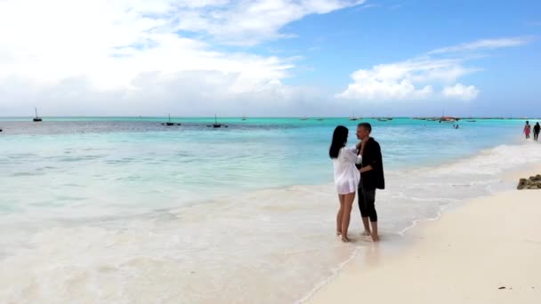 Romantický pár tančí ve vodě, milenci si užívají letní dovolenou a relaxaci na pláži. Šťastný pár pohybující se jejich těla, energický pár na pláži - Záběry, video
