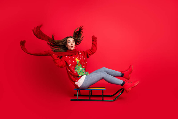 Full length body size profile side view of her she attractive cheerful cheery amazed girl sitting on sledge having fun riding season leisure isolated bright vivid shine vibrant red color background - Fotografie, Obrázek