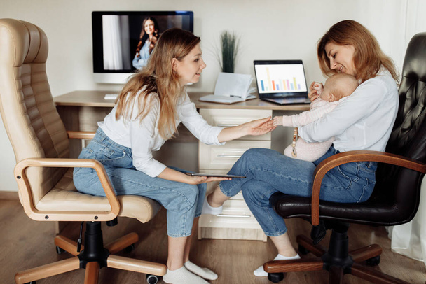Happy woman take a break from work to spend time with little daughter, young mother working from home, while loving grandmother babysit newborn baby girl, young mother working home - Foto, Bild