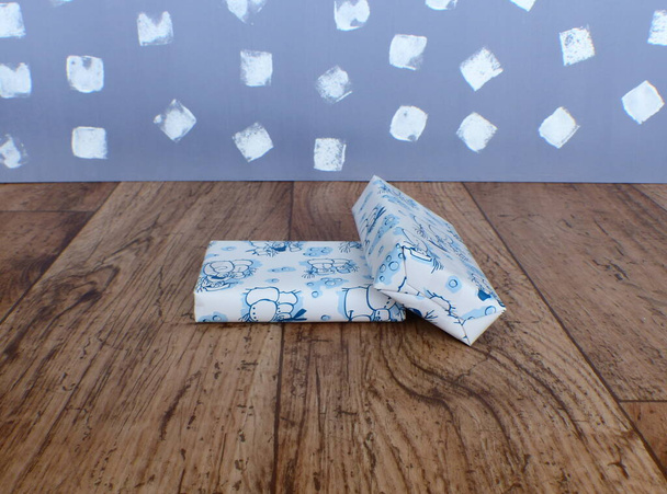 подарки, завернутые в сине-белую бумагу с мотивами снеговика - Фото, изображение