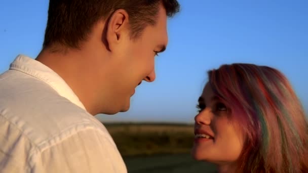 Mężczyzna i kobieta rozmawiają i całują się stojąc na letnim polu w zwolnionym tempie - Materiał filmowy, wideo