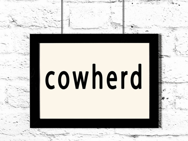 Black frame hanging on white brick wall with inscription cowherd - Photo, Image