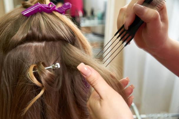 Coiffeur coiffant les cheveux d'un client dans un salon de beauté - Photo, image