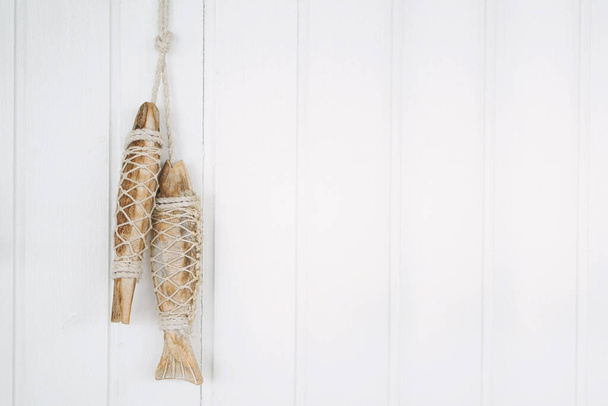Hand crafted fish wood on white wooden background with copy space. - Photo, Image