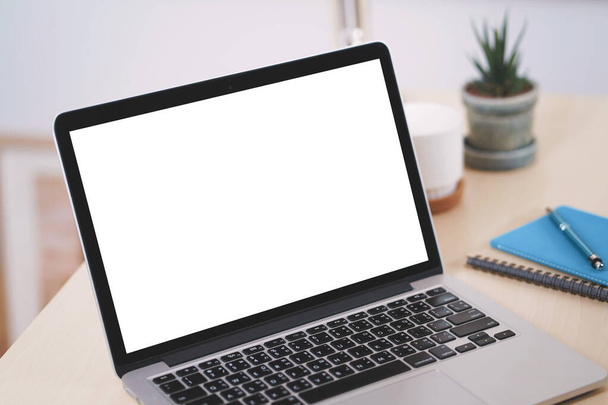Espacio de trabajo conceptual, ordenador portátil con pantalla blanca en blanco en la mesa. - Foto, Imagen