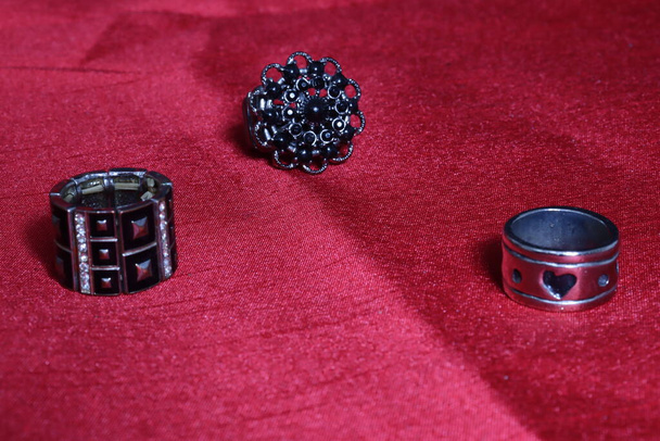 Několik ženských prstenů různých velikostí na červeném pozadí - Fotografie, Obrázek