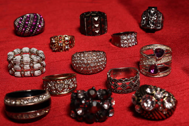 Několik ženských prstenů různých velikostí na červeném pozadí - Fotografie, Obrázek