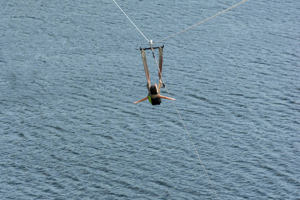 6 yaşında bir çocuk, Ceara-Mirim / RN-Brazil şehrindeki Jacoma Lagoon 'da zip halatıyla batıyor.. - Fotoğraf, Görsel