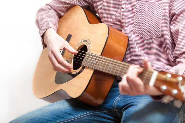 Shot of man in shirt and jeans playing on classic guitar - Photo, Image