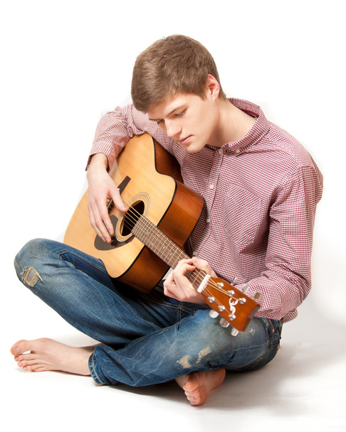 człowiek siedzi na podłodze i gra na gitarze klasycznej - Zdjęcie, obraz