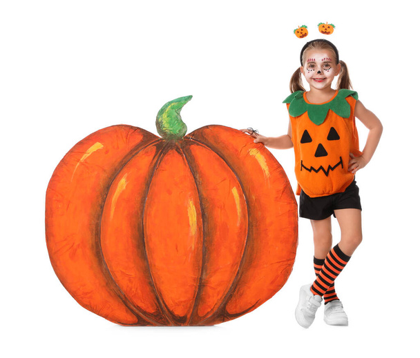 Cute little girl wearing Halloween costume and decorative pumpkin on white background - Foto, afbeelding