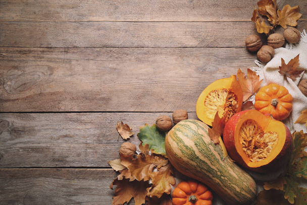 Плоская композиция с овощами, орехами и осенними листьями на деревянном столе, место для текста. День благодарения - Фото, изображение