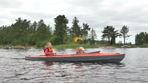 母はカヤックを漕いで森の近くの湖を航海し - 映像、動画