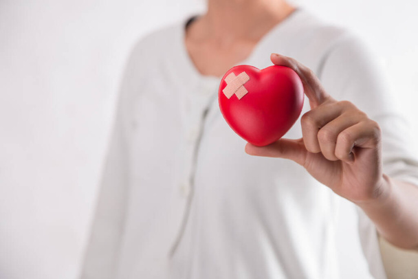 Donna con il cuore rosso simbolo della Giornata Mondiale del Cuore. Fondo bianco isolato. - Foto, immagini