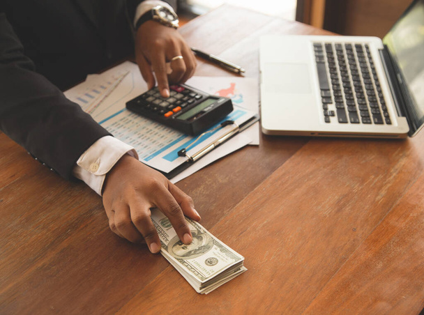 Close up de homem de negócios com calculadora contando dinheiro. na sala da empresa. - Foto, Imagem