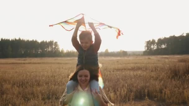 Maman et petit fils jouent avec un cerf-volant dans la prairie - Séquence, vidéo