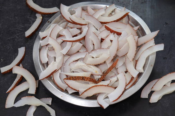 Vue rapprochée des chips de noix de coco séchées sur fond gris en Inde - Photo, image
