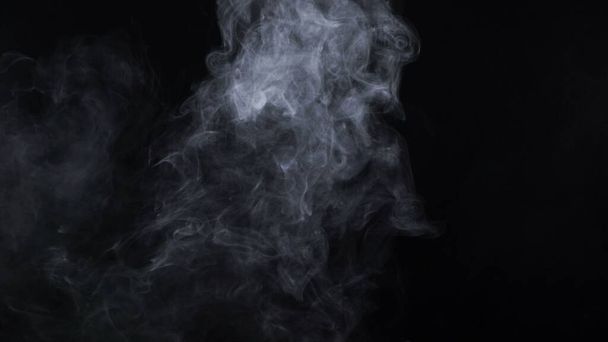 Cloudy smoke of electronic cigarette on black background - Photo, Image