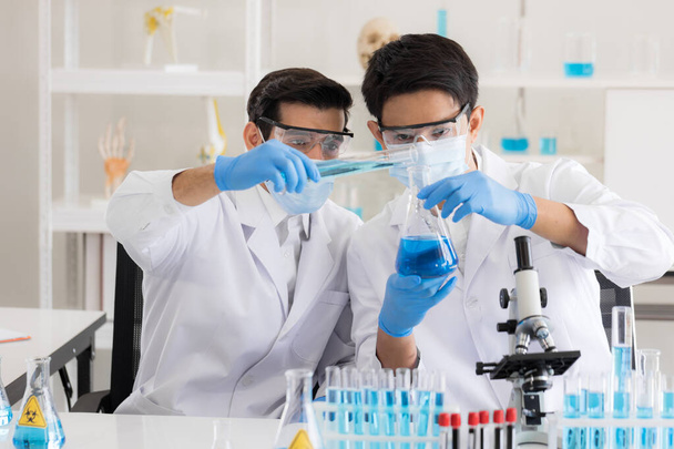 Health care researchers working in life science laboratory. Male research scientist and supervisor preparing and analyzing microscope slides in research lab. Invention of the coronavirus vaccine - Photo, Image